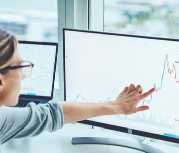 Business woman study financial markets on computer - Business Services